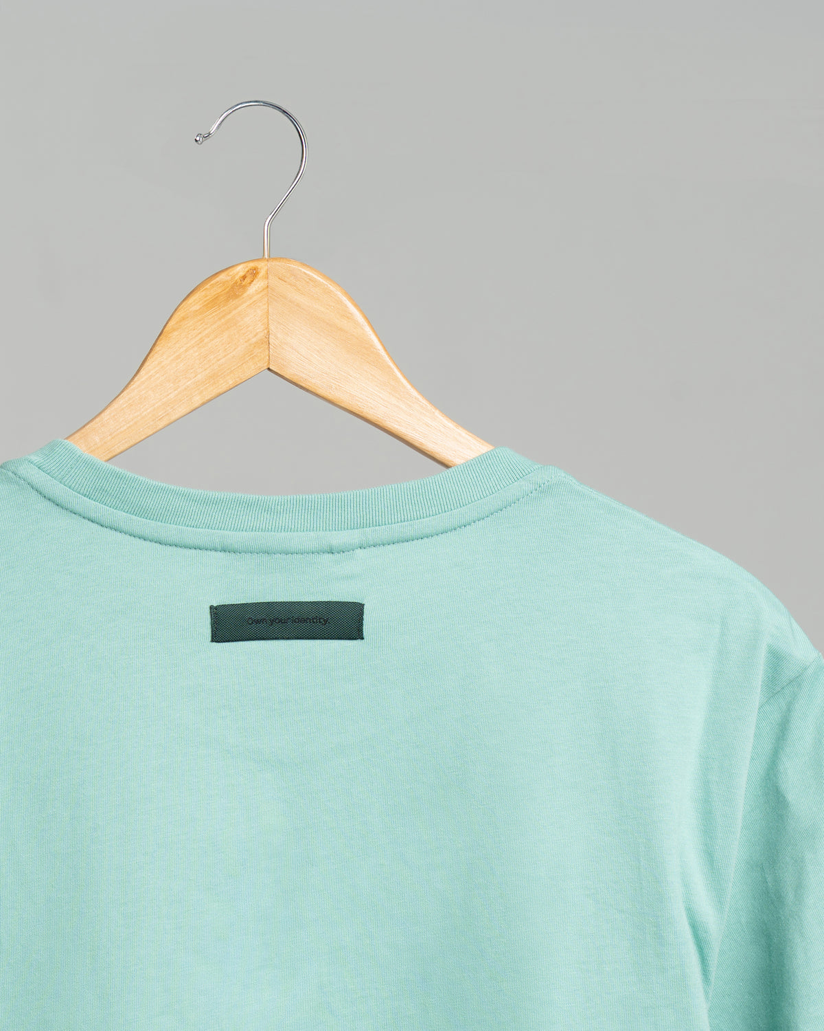 Close-up of the back statement print on the green SELECT DISTINCT ORIGIN Essentials No.1 T-shirt in 100% organic cotton.