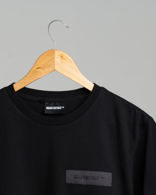 Close-up of the front SELECT DISTINCT logo on the black ORIGIN Essentials No.1 T-shirt in 100% organic cotton.